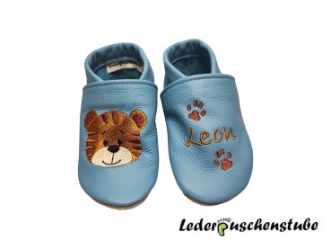 Lederpuschen hellblau mit rechts Stickerei Tigergesicht ocker-rotbraun-creme-schwarz und links Namen ocker mit 2 Tatzen rotbraun
